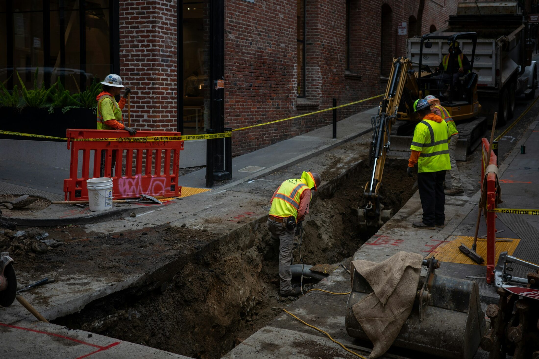 Commercial underground utility crew trenching in an urban corridor